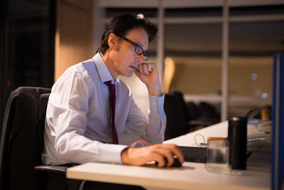 Man using mobile phone while sitting on table