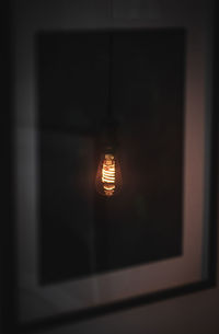 Close-up of illuminated light bulb at home