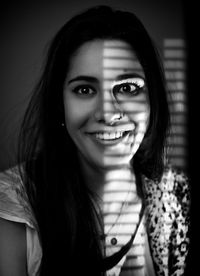 Portrait of smiling young woman with shadow on face