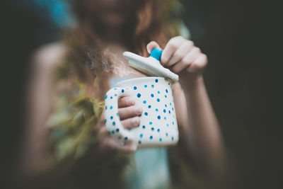 Midsection of woman holding cup with steam