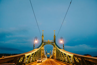 Illuminated bridge against sky at dusk