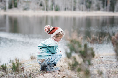 Young girl sitting on a rock smiling whilst hiking in sweden