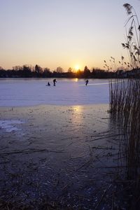 Scenic view of lake against sky during sunset