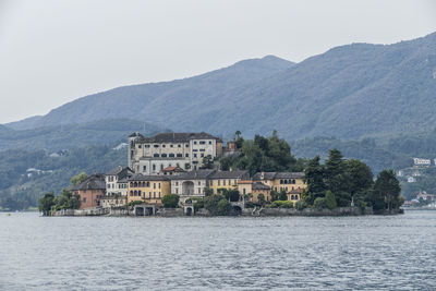 Buildings by mountains against sky