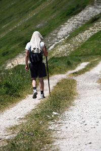 Rear view of man walking on footpath