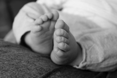 Low section of baby lying on bed