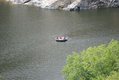 High angle view of tourists riding on coracle amidst lake