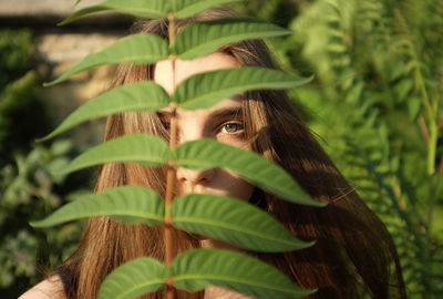 Portrait of young woman with plant