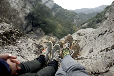 Low section of friends resting on rock formation