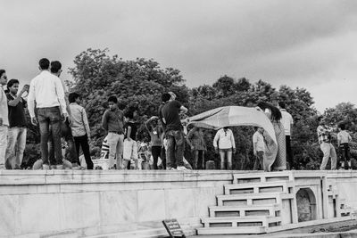 People standing by statue against sky
