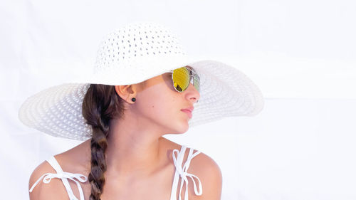 Teenage girl wearing hat against white background