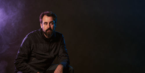 Great copy space in panoramic of a man in a recording stidia with smoke and colored lights