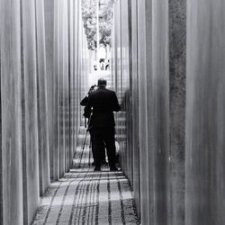 Rear view of man walking in narrow alley