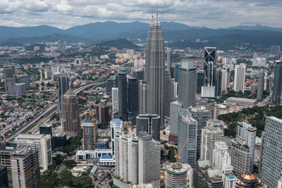 Petronas towers in city against sky