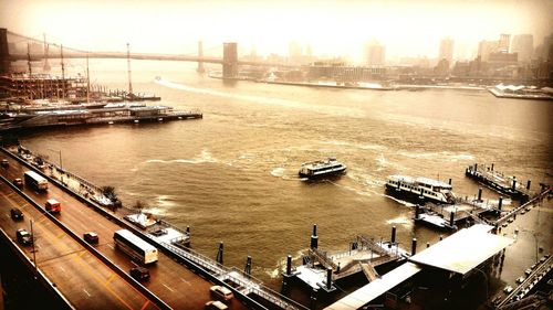 Boats in river with city in background