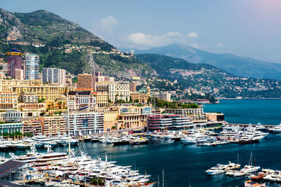 Aerial view of cityscape by sea against sky