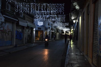 Man walking on illuminated street at night