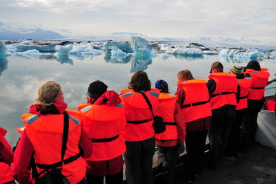 Rear view of people wearing life jackets