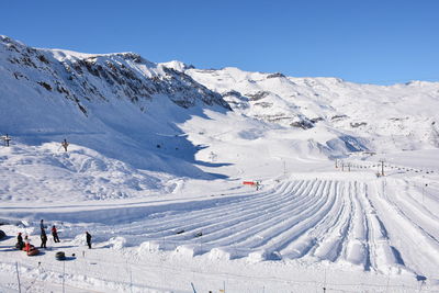 Scenic view of snowcapped mountains against clear blue sky