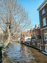 Canal amidst buildings against sky