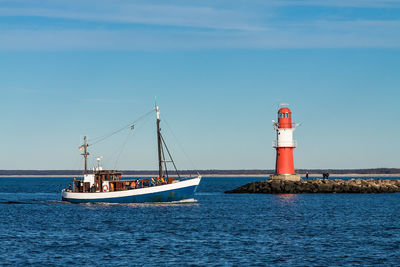 Lighthouse on sea against sky