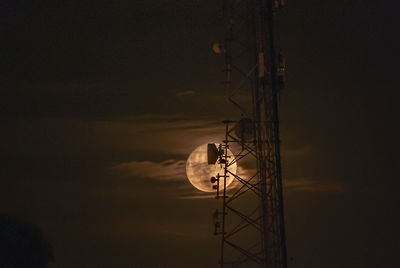 Low angle view of communications tower against sky at night