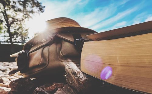 Close-up of sunglasses on wood against sky