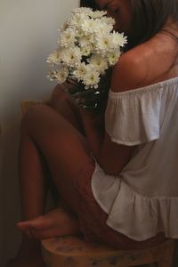 Midsection of woman holding bouquet