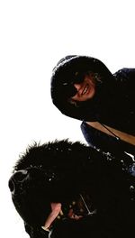 Portrait of young man with dog against white background