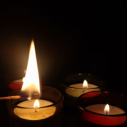 Close-up of lit candle in the dark