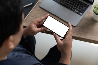 Midsection of man using digital tablet