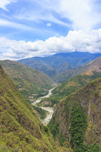 Scenic view of valley and mountains against sky