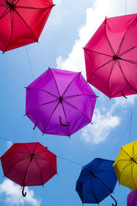 Low angle view of umbrellas hanging against sky