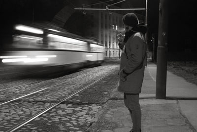 Rear view of man standing at railroad station