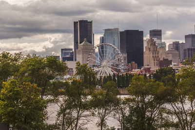 View of ferris wheel in city against sky