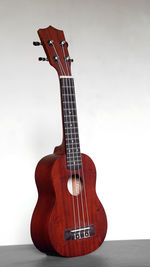 Close-up of guitar on table against white background