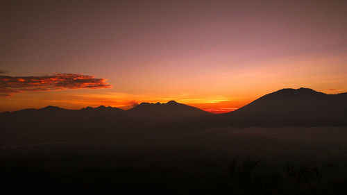 Colorful sunrise on top of kelud mountain with view kawi mountains