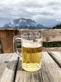 Glass of beer on table against sky