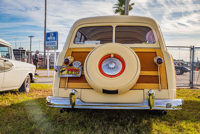 Vintage car on field against sky