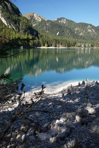 Scenic view of lake by mountains against sky