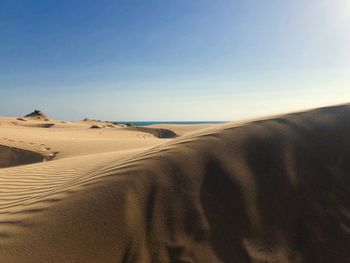 Sand dunes in desert against clear sky