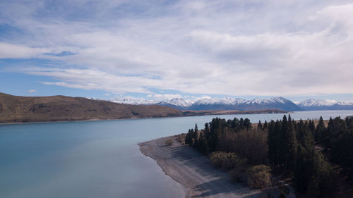 Scenic view of lake by mountains against sky