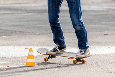 Low section of man skateboarding on road