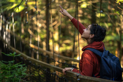 Side view of child looking through trees