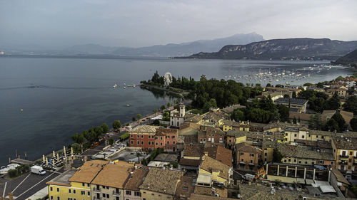 High angle view of townscape by sea against sky