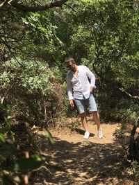 Full length of young man walking in forest