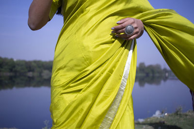 Rear view of woman standing on yellow leaf