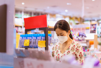 Portrait of young woman standing in store