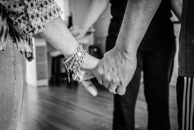 Midsection of couple holding hands