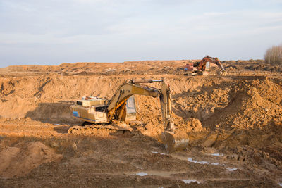 Excavators working at open-pit mining. backhoe during earthworks on sand quarry. earth-moving 